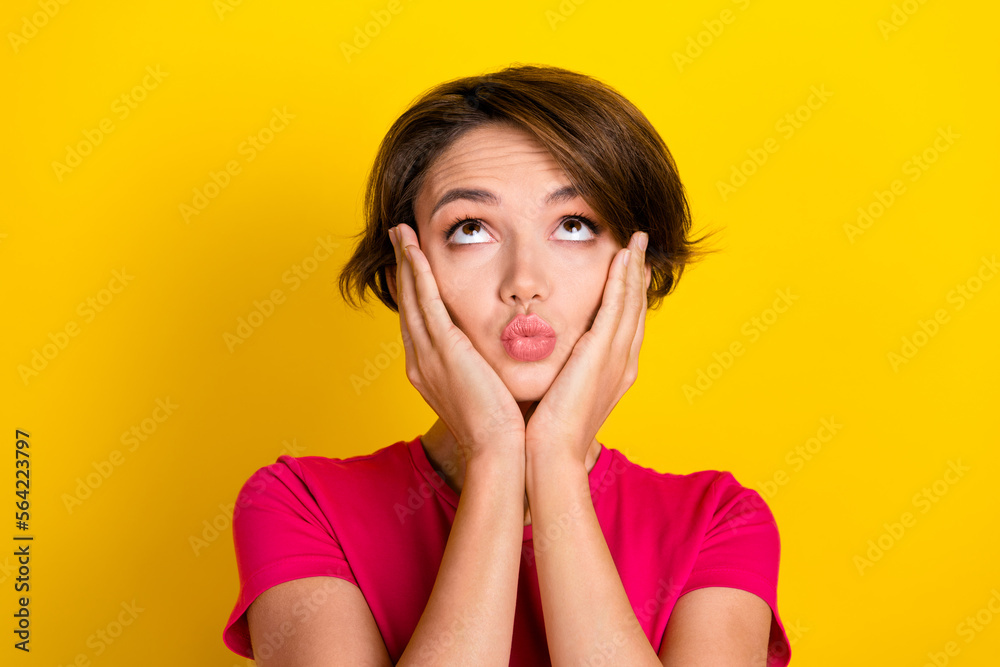 Photo of dreamy funny woman dressed pink t-shirt lips pouted arms cheeks looking up empty space isolated yellow color background Photo of dreamy funny woman dressed pink t-shirt lips pouted arms cheeks looking up empty space isolated yellow color background