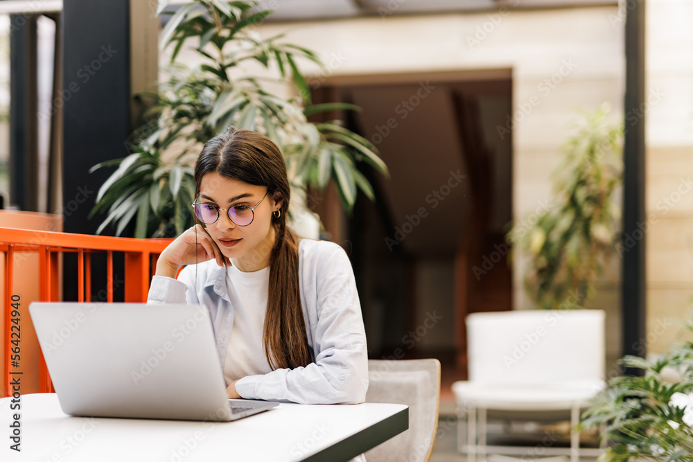 Businesswoman using a laptop, sitting at the office. Businesswoman using a laptop, sitting at the office.