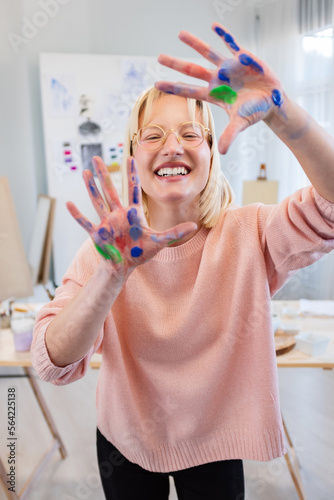Young woman at art studio smiling, making frame with hands and fingers with happy face