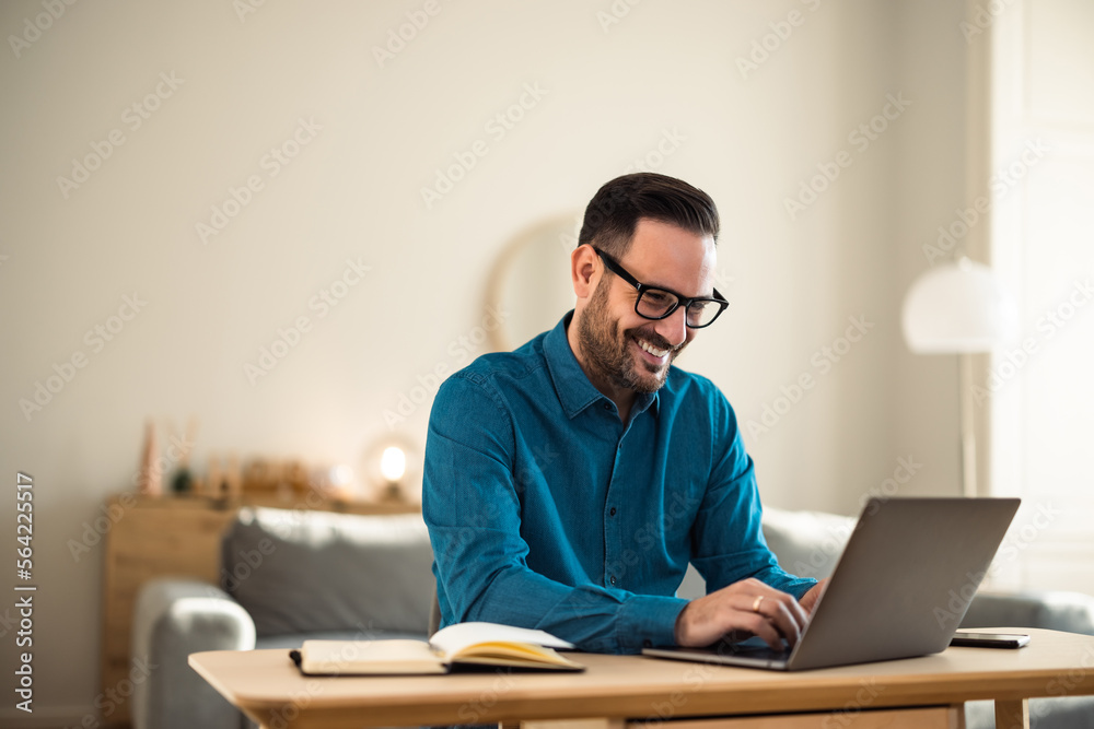 Smiling man working over the laptop, sitting at the workplace, elegantly dressed. Smiling man working over the laptop, sitting at the workplace, elegantly dressed.