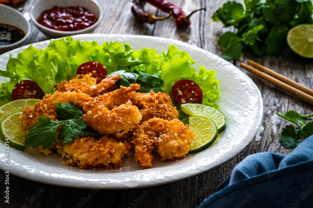 Fried panko prawns with lime, tomatoes and greens wooden table
Fried panko prawns with lime, tomatoes and greens wooden table