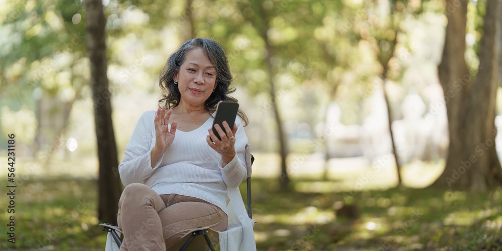 Happy senior asian woman at outdoor park and talking on video call with family Happy senior asian woman at outdoor park and talking on video call with family