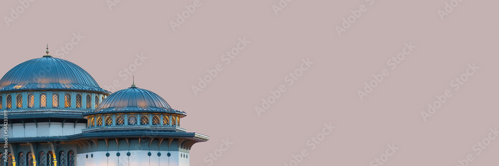 Istanbul, Turkey (Turkiye). Taksim Mosque (Taksim Camii). Mosque complex at Taksim Square at blue houe with backlight. Close up fragment. Isolated, banner, solid color background