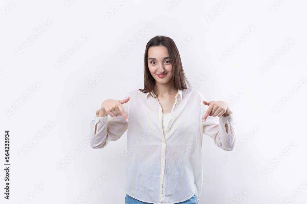 Happy young caucasian female in a shirt pointing fingers away