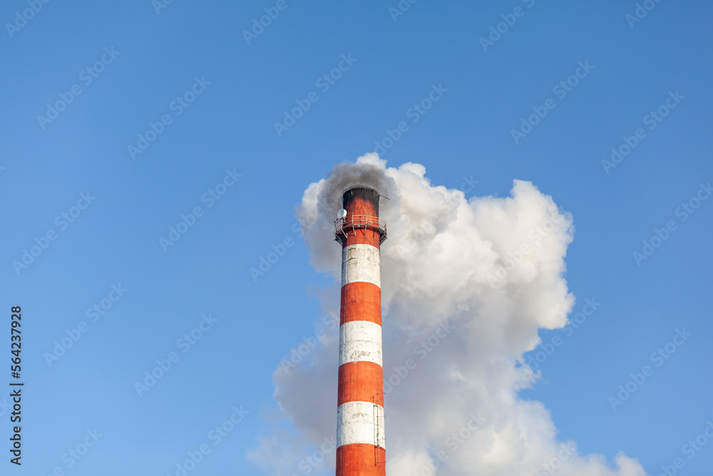 White thick smoke from the boiler room chimney. Smoke against the blue sky. Air pollution. Heating of the city. Industrial zone. White thick smoke from the boiler room chimney. Smoke against the blue sky. Air pollution. Heating of the city. Industrial zone.