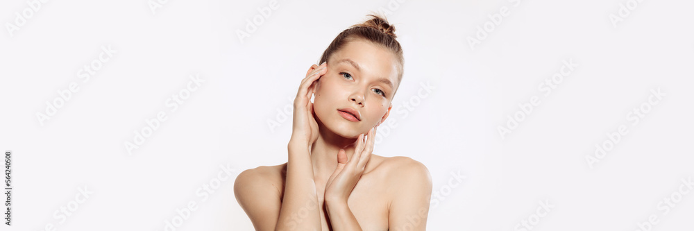 Tender, young, beautiful girl with perfect well-kept skin over white background. Taking care after skin with natural cosmetics. Concept of cosmetology, plastic surgery, natural beauty. Banner, flyer. Tender, young, beautiful girl with perfect well-kept skin over white background. Taking care after skin with natural cosmetics. Concept of cosmetology, plastic surgery, natural beauty. Banner, flyer.