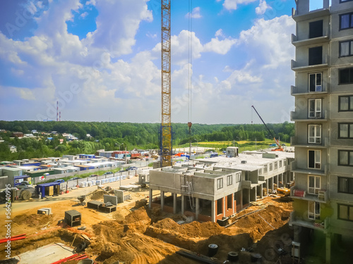 tower crane builds a high-rise monolithic-frame house at the construction site of concrete high-rise buildings. Construction of apartments in a new residential complex