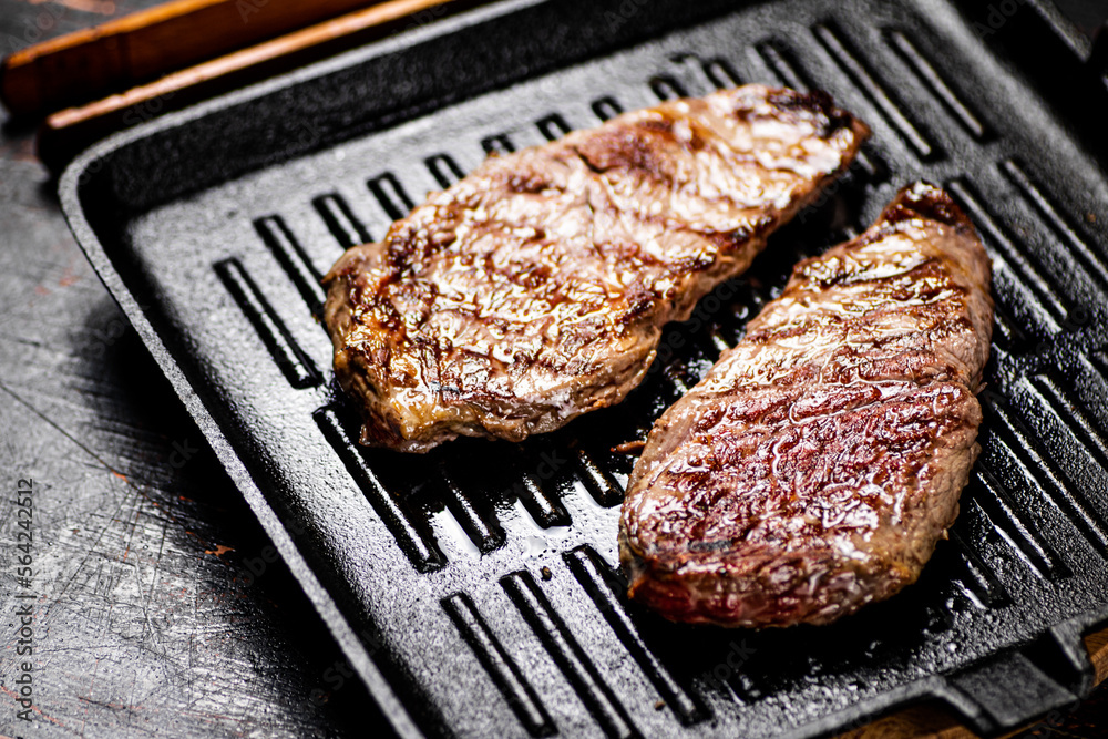 Aromatic grilled steak in a frying pan. 