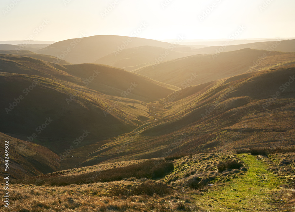 The twisting valley of Rowhope Burn from the summit of Black Braes on a sunny winters morning in the Northumberland Cheviot mountains at sunrise, UK.