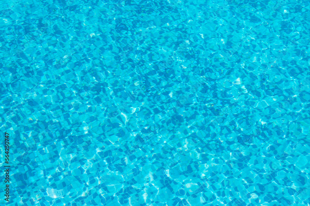 Background and rippled pattern texture of clear water in blue swimming pool.