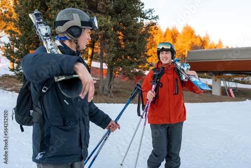 Two boys walking with ski equipment