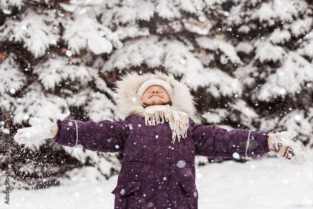 Fototapeta premium Happy Winter Children Holidays. Little Girl Child Smiling Having Fun Playing Enjoying Snow Winter in Snowy Background.