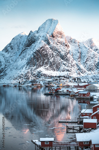 Morning sunrise in Reine, unbelievable view on small fishing village in Lofoten, Norway, Epic snowy mountains and red cabins with water, beautiful background picture from wild nature 