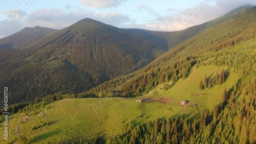 4k drone forward video (Ultra High Definition) of Carpathian mountains, Dzembronya village location, Ukraine, Europe. First sunlight glowing mountain valley at June. Traveling concept background.. photo