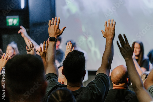 Hands in the air of people who praise God at church service photo