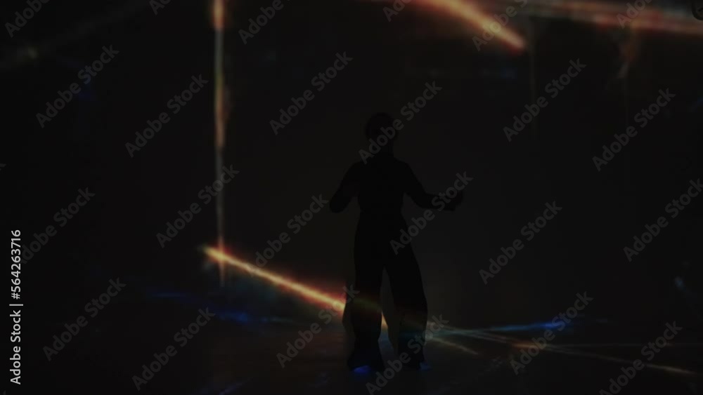 teen girl dancing popping style in dark room with art laser lights on walls, silhouette shot teen girl dancing popping style in dark room with art laser lights on walls, silhouette shot