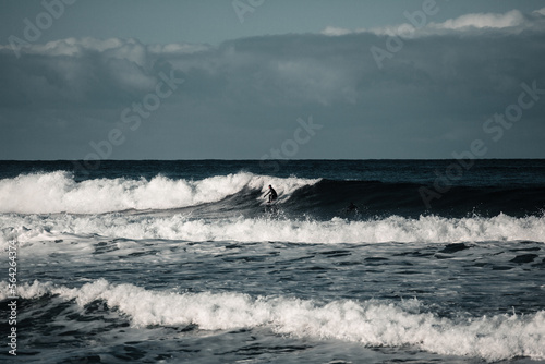 Arctic surfer in Unstad beach, Lofoten, Norway during cold winter time with big waves 