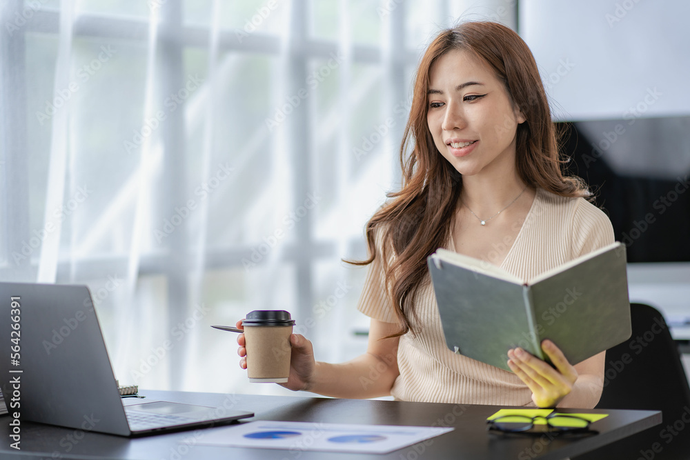Asian businesswoman working with financial documents and laptop Inside office worker calculating financial indicators smiling and happy with success and results of business success Asian businesswoman working with financial documents and laptop Inside office worker calculating financial indicators smiling and happy with success and results of business success