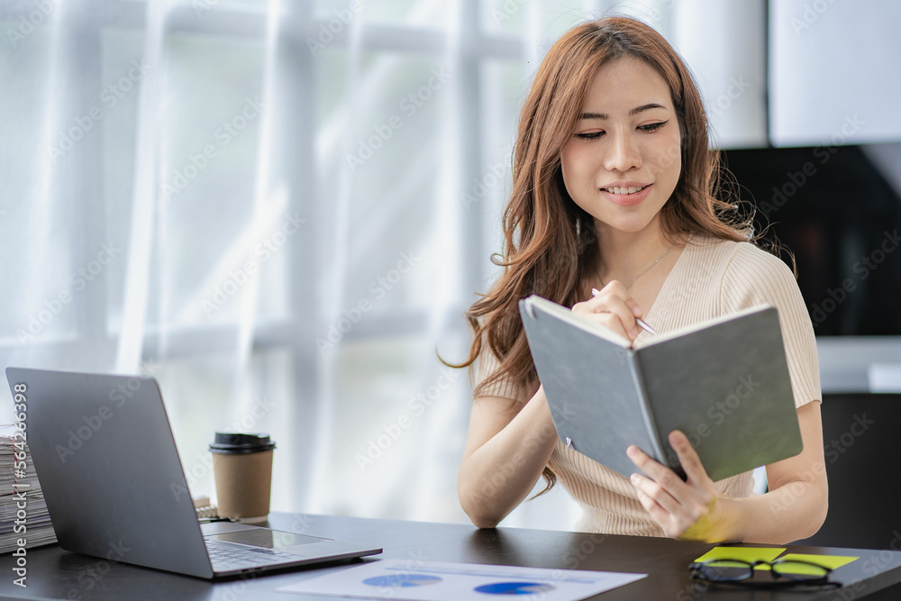 Asian businesswoman working with financial documents and laptop Inside office worker calculating financial indicators smiling and happy with success and results of business success Asian businesswoman working with financial documents and laptop Inside office worker calculating financial indicators smiling and happy with success and results of business success