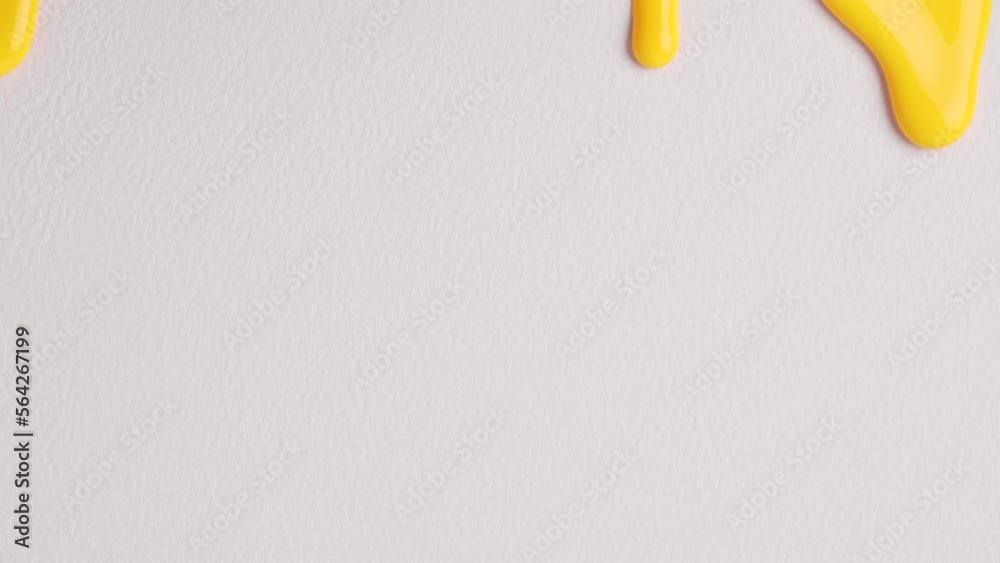  Liquid drops of yellow paint color flowing on the white surface. Macro Shot of yellow paint dripping on the white wall with copy space. Production Close-up. Slow Motion, Abstract art.