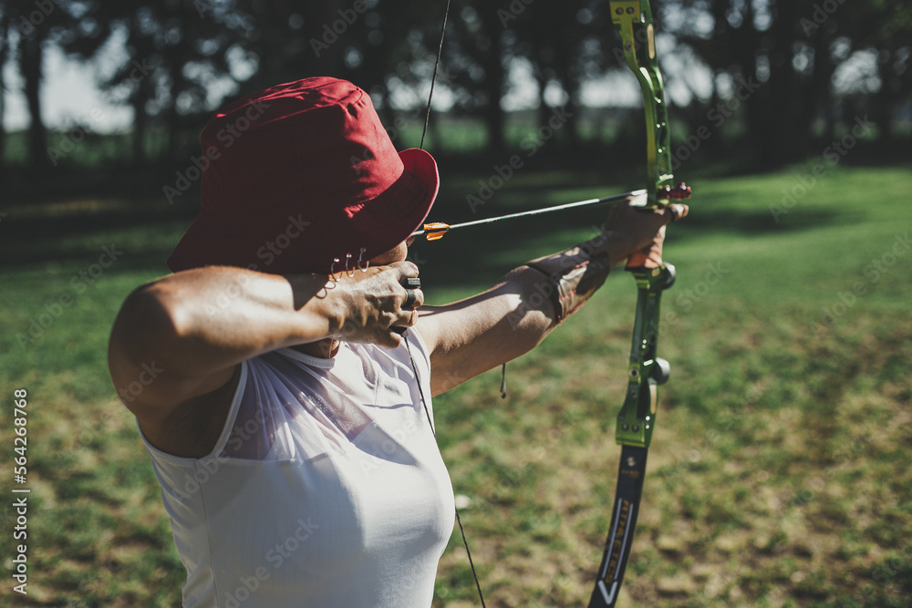 mujer practicando tiro con arco raso - obrazy, fototapety, plakaty 