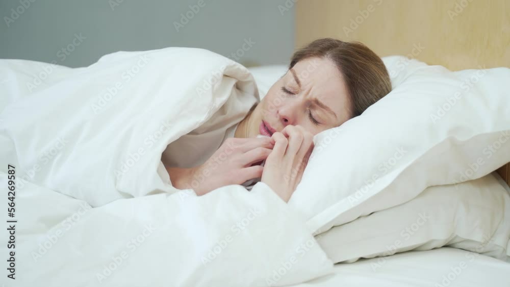 Sick blond woman blowing running nose sneezing and coughing laying on the warm bed in the bedroom Unhealthy female under the blanket getting flu virus symptom Cold and fever concept Sick blond woman blowing running nose sneezing and coughing laying on the warm bed in the bedroom Unhealthy female under the blanket getting flu virus symptom Cold and fever concept
