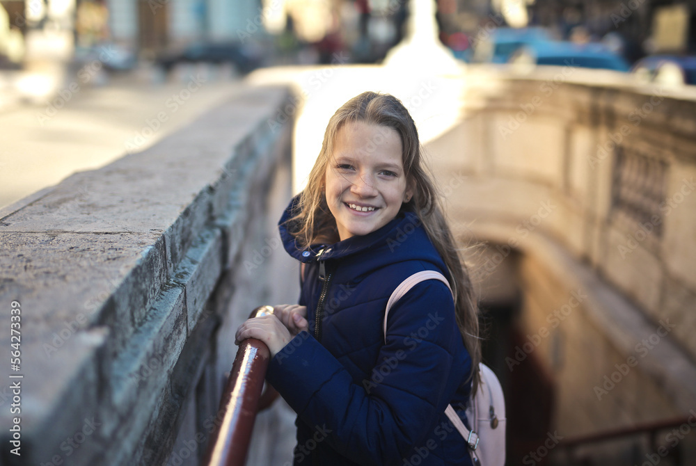 Fototapeta premium little girl on the stairs at the entrance to the subway in the city