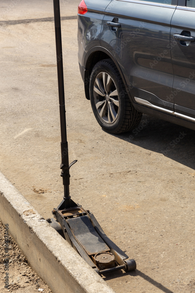 Fototapeta premium Hydraulic car jack lift the new car for change the tyre.