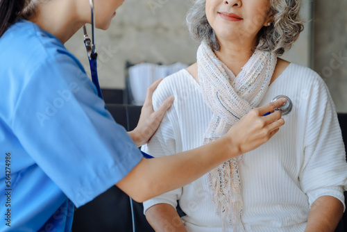 Fotografiet Doctor with stethoscope examining elderly patient with examination, presenting symptoms and recommending treatment, healthcare and medical concept