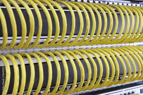 Ethernet sockets of the switch with yellow patch cords connected to them with an RJ45 connector.