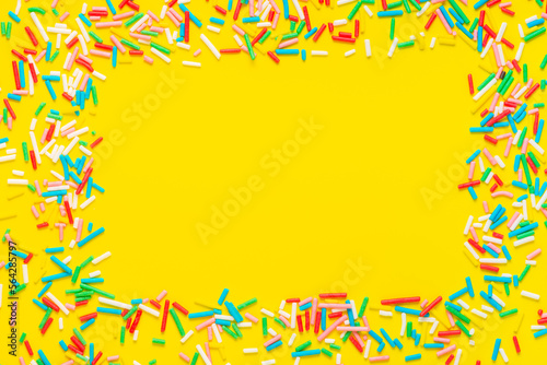 greeting wreath of colorful sprinkles on yellow background, festive invitation for Valentines day, birthday, holiday and party time