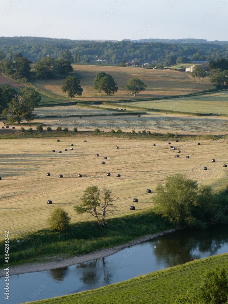 Summertime view down onto the River Wye from Ballingham Hill, Herefordshire, with bales dotted in the fields
