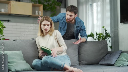 Aggressive young bearded man yells at his scared wife swung and threatens to beat Terrified woman close her ears and try to protect herself from an cruel husband at home Domestic violence abuse