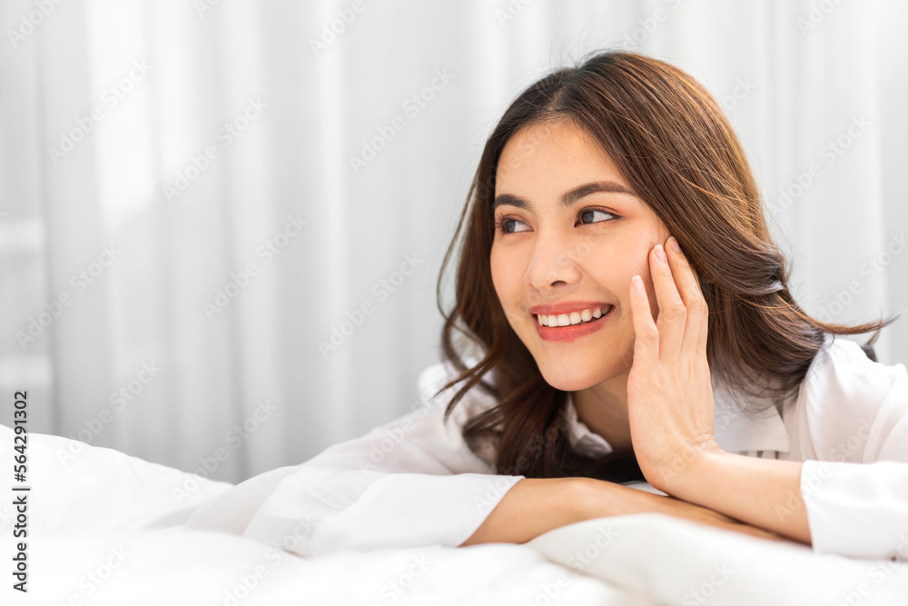 Portrait of smiling cheerful beautiful pretty asian woman clean fresh healthy white skin posing smile in pajamas white clothes.Girl felling relax and enjoy time on the bed at home.asia beauty Portrait of smiling cheerful beautiful pretty asian woman clean fresh healthy white skin posing smile in pajamas white clothes.Girl felling relax and enjoy time on the bed at home.asia beauty