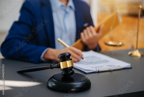 Fototapeta Naklejka Na Ścianę i Meble -  justice and law concept.law theme  wooden desk, books, balance. Male judge in a courtroom the gavel,working with digital tablet computer