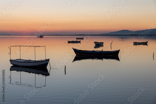 View of boats on sunset with reflection on the sea, colorful sky and clouds on sunset time with silhoutte of vehicles