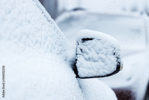The side mirror of a car covered in snow. Selective focus copy space © Mikhail