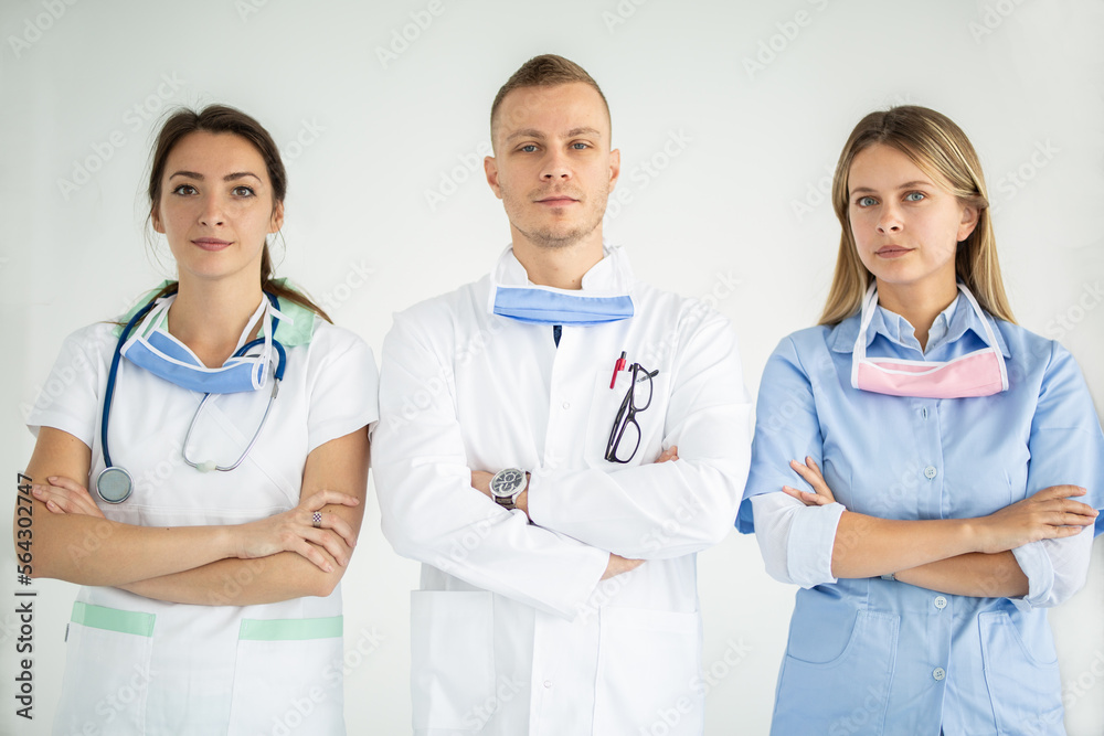 Doctors standing with their arms crossed and looking at the camera confidently Doctors standing with their arms crossed and looking at the camera confidently