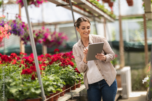 Young Gardener With Digital Tablet In A Greenhouse