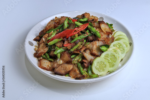 Stir Fried Pork Curry with Long Beans Served with cucumber as a side dish and steamed rice, ready to eat.