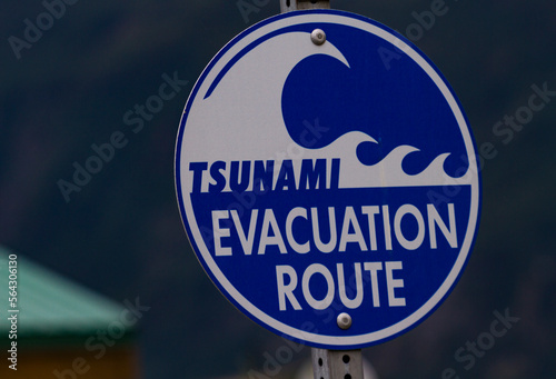 Road sign indicating emergency Tsunami Evacuation Route is public safety help in natural disaster in Port Valdez, Alaska, along coastal area of Prince William Sound