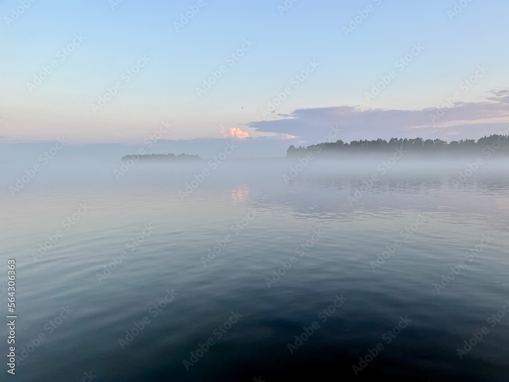 Tender fog at the lake, bright blue and purple sky, natural misty lake background