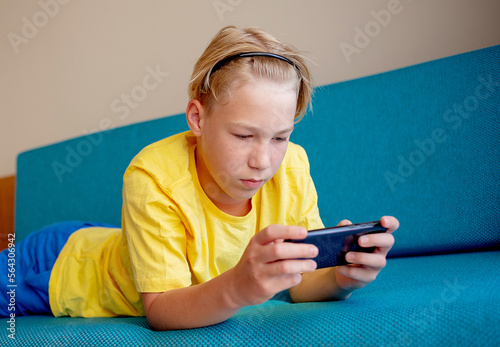 happy teennager looking at cell phone in living room at home photo