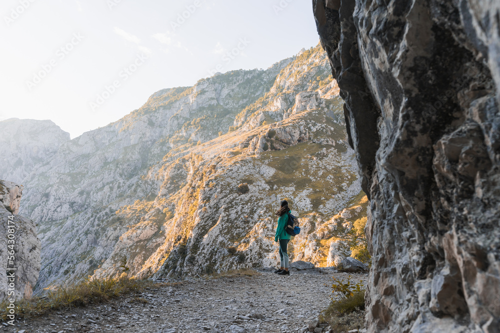 Unrecognizable traveler walking on mountain slope Unrecognizable traveler walking on mountain slope