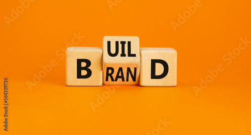 Build your brand symbol. Concept word Build brand on wooden cubes. Beautiful orange table orange background. Business and build your brand concept. Copy space. photo