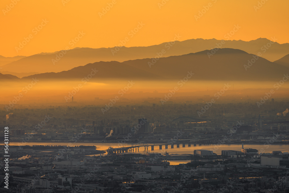 Thick layer of smog over industrial city with orange glow in sky at dawn