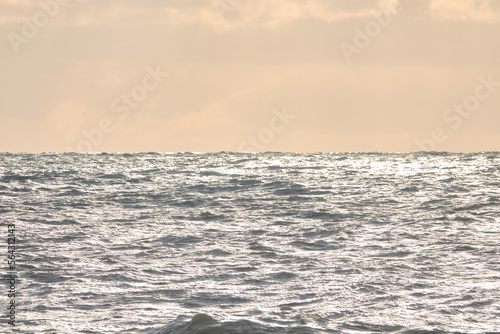 Sea waves at sunset. Sun glare in the waves.