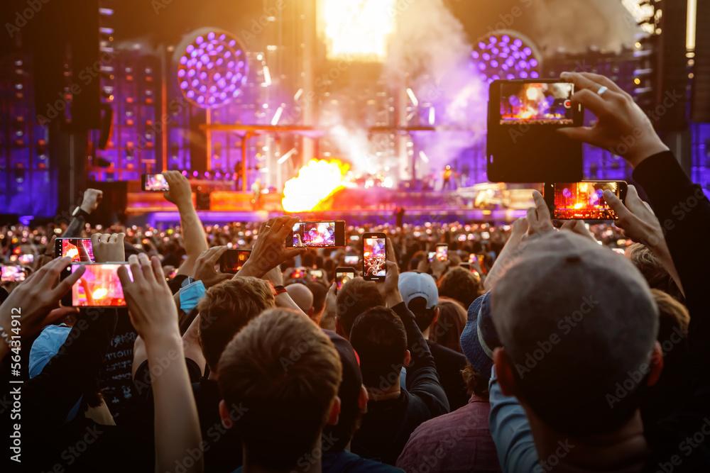 Hand with a smartphone record live music festival and taking photos of the concert. Hand with a smartphone record live music festival and taking photos of the concert.