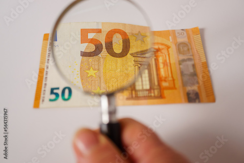 fifty euro banknote viewed with a magnifying glass photo