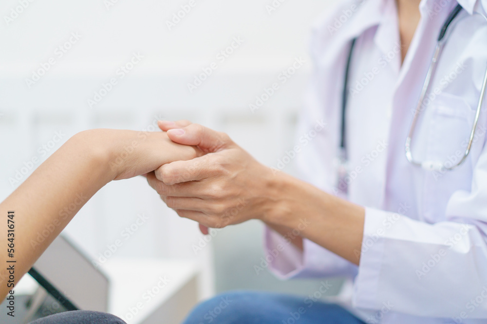 Female specialist or professional doctor giving a consulting to female patient in clinic. Doctor touching or holding on crisis patient's hand with empathy and care. Female specialist or professional doctor giving a consulting to female patient in clinic. Doctor touching or holding on crisis patient's hand with empathy and care.